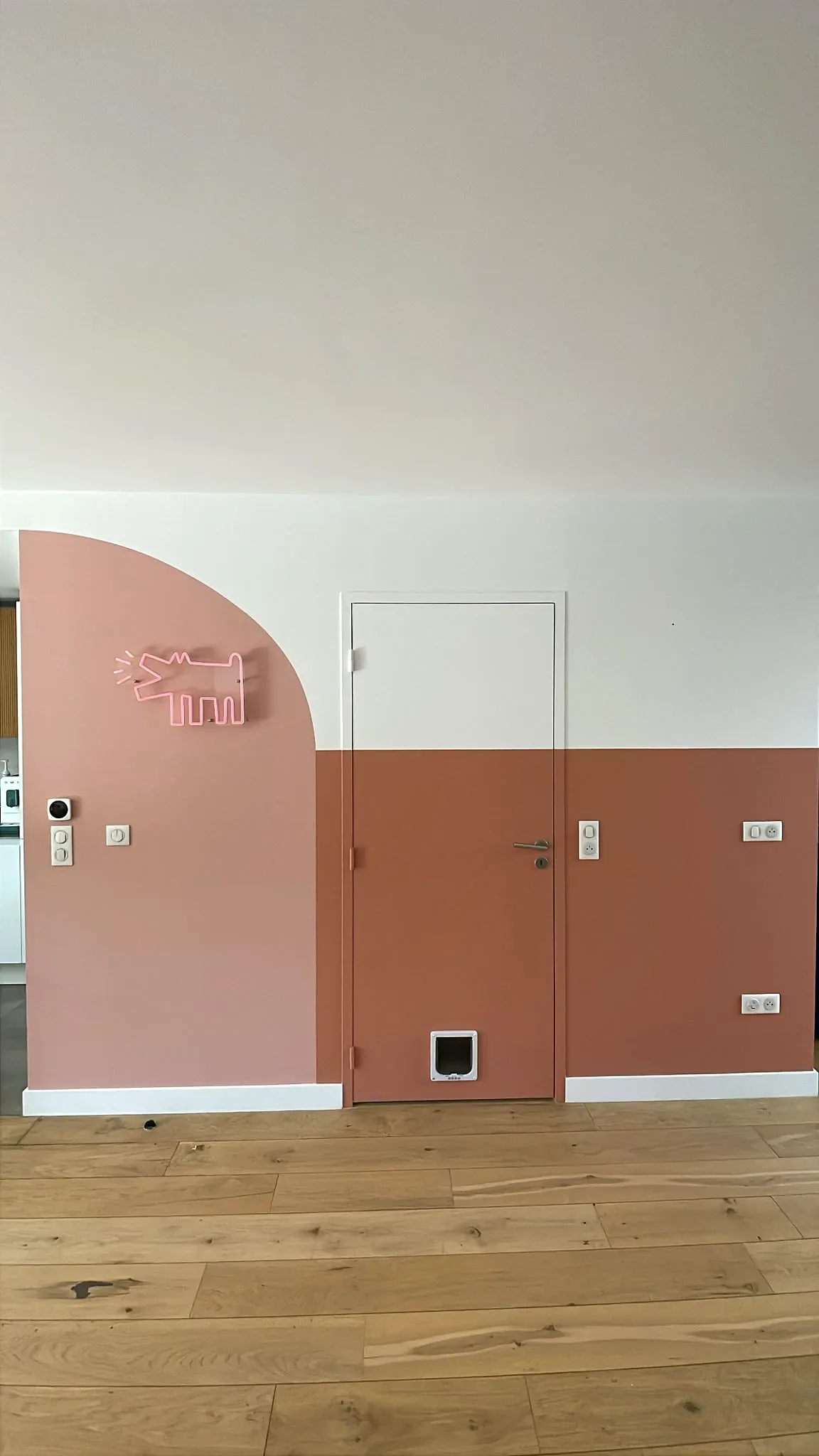 Vue de face d'une chambre avec soubassement rose et murs blancs