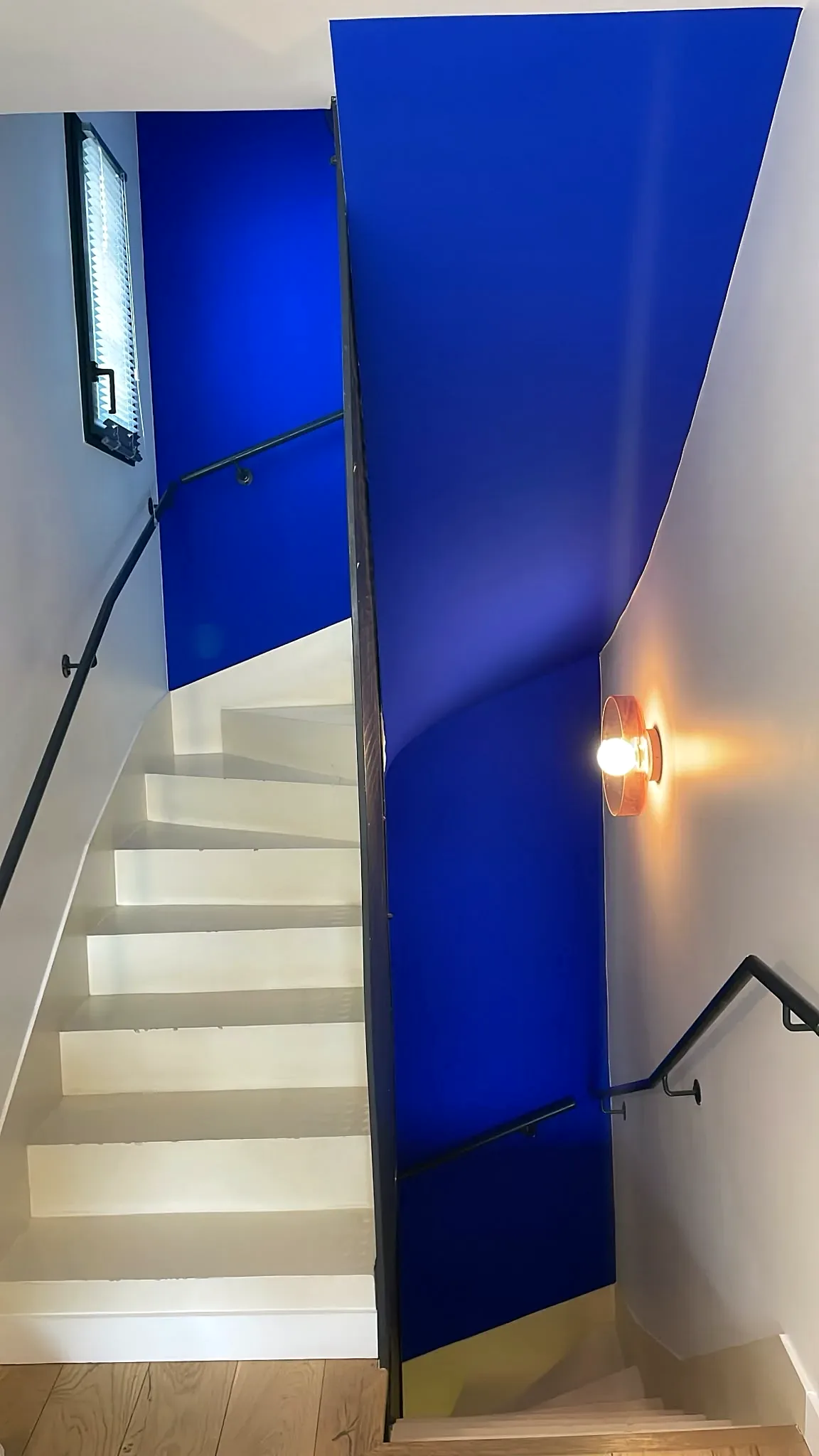 Escalier blanc rénové avec murs et plafond bleu intense
