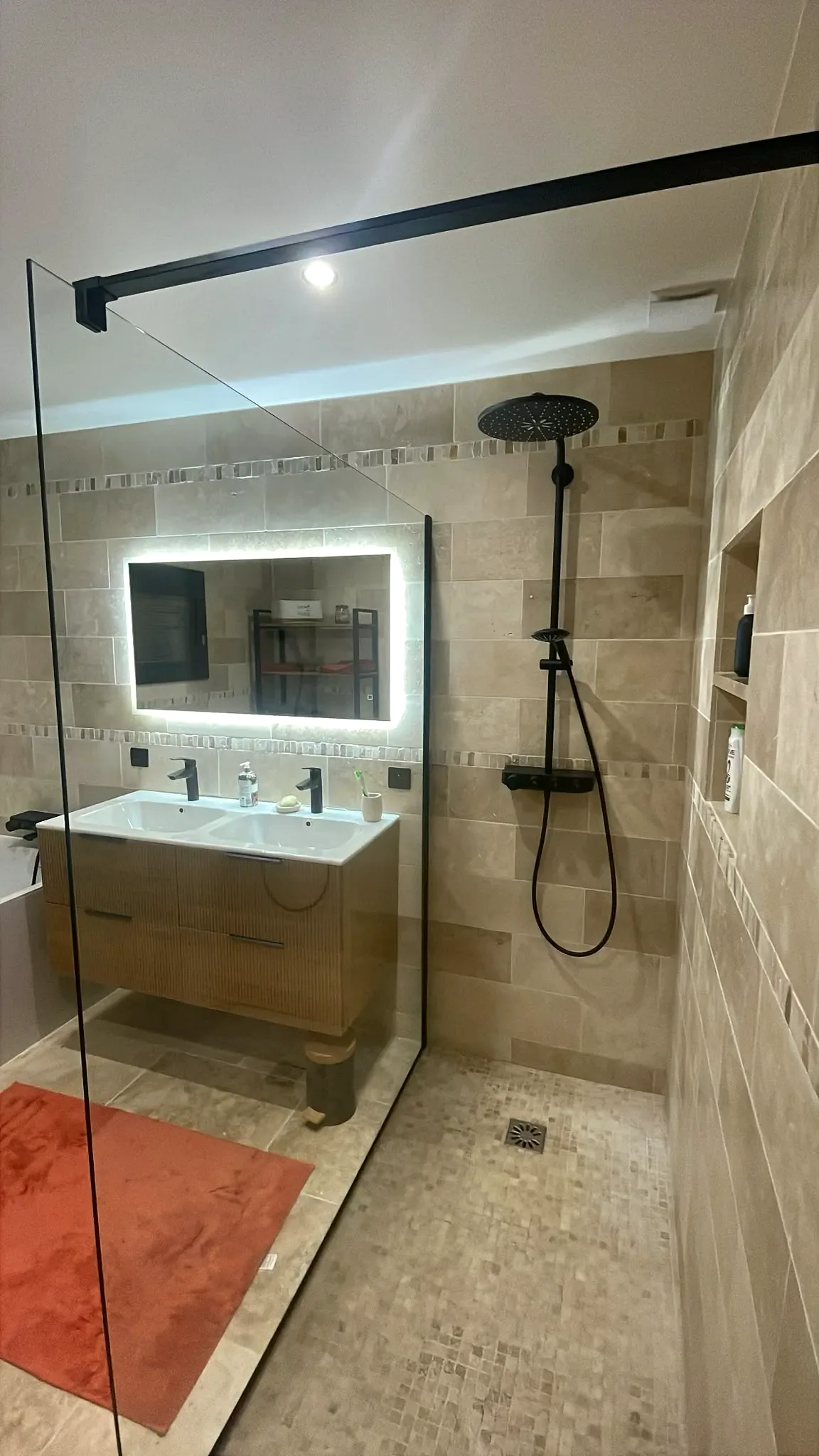 Douche à l'italienne et meuble double vasque dans une salle de bain rénovée